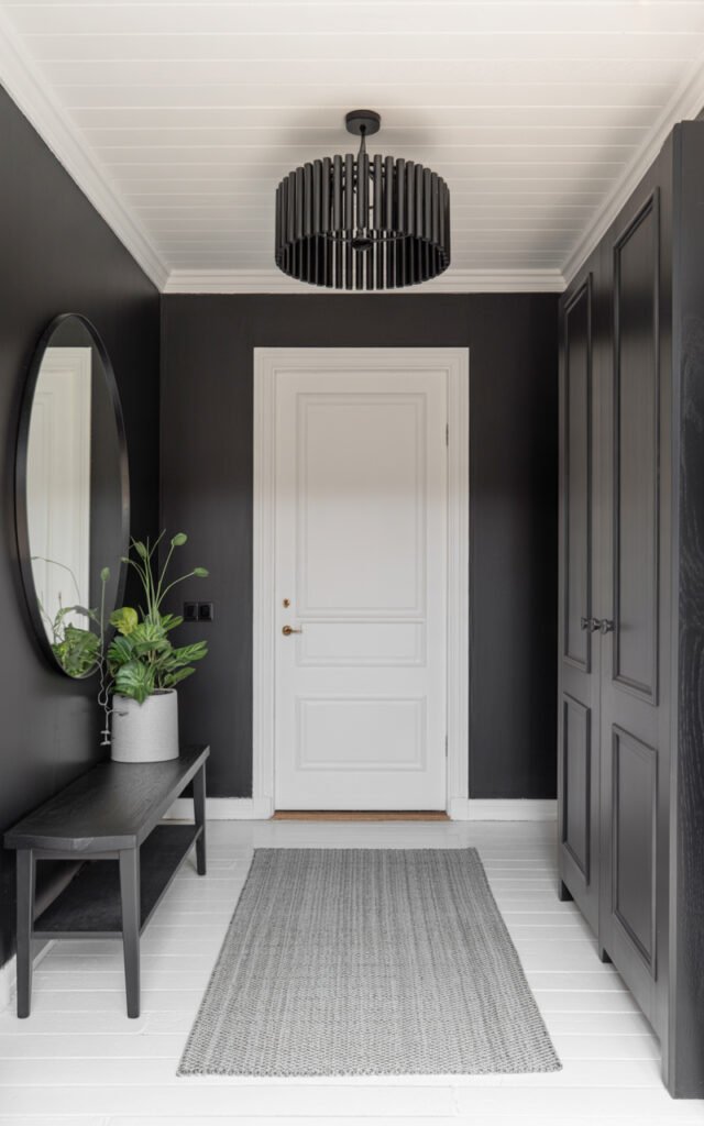 Black and white entryway showing balanced contrast with white ceiling black walls and patterned rug