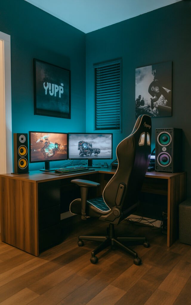 L shaped corner desk with dual monitors gaming PC and racing chair in dark bedroom