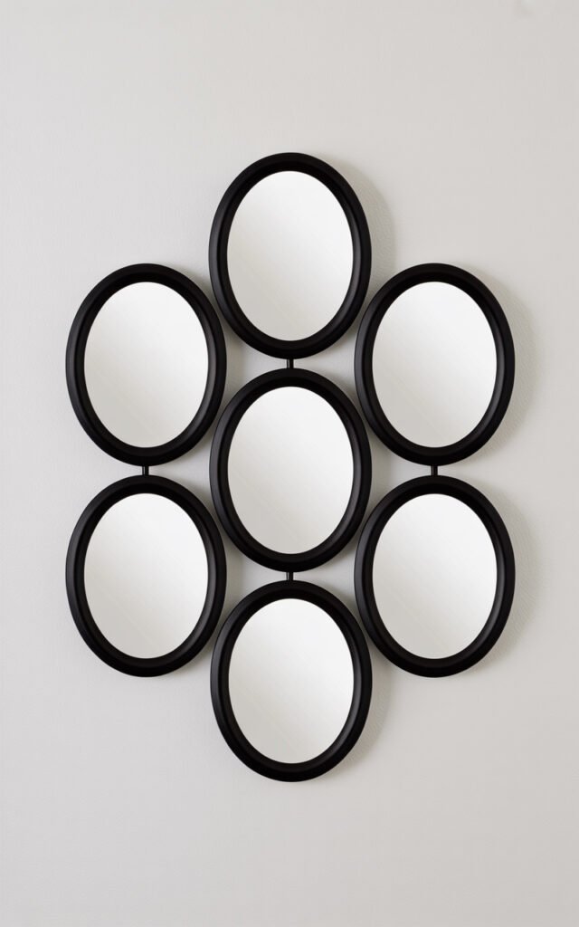 Six small oval mirrors with black frames arranged in honeycomb cluster creating affordable wall art