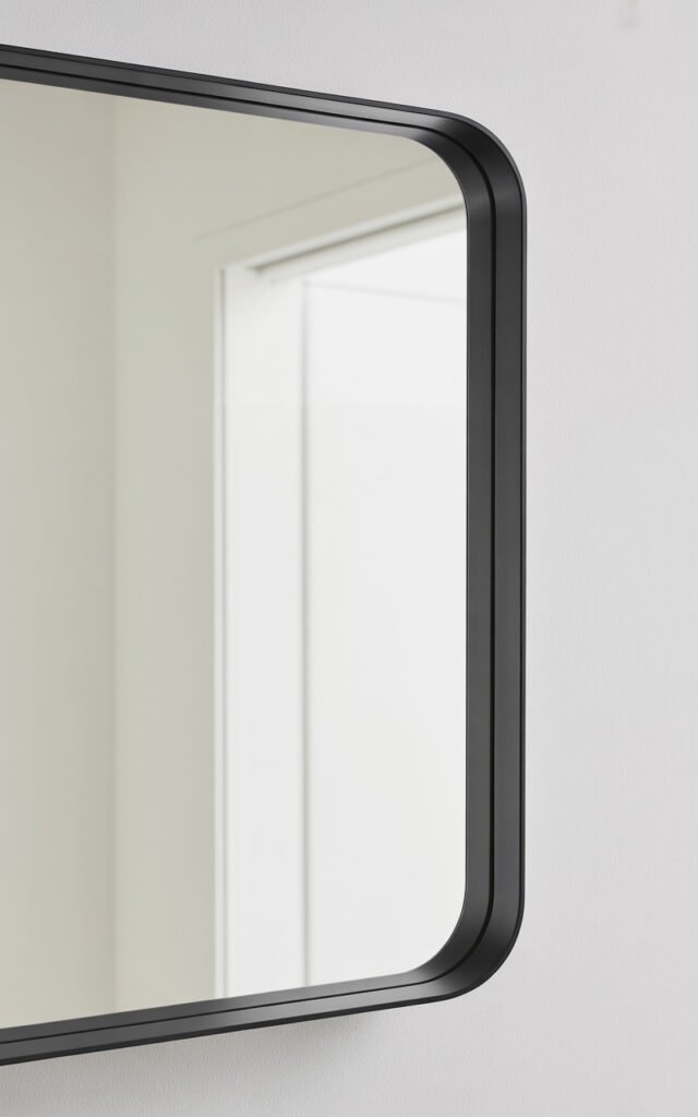 Close-up of IKEA LOTS square mirror with thin black frame on white wall