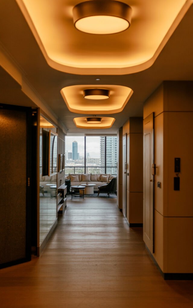 Luxury modern apartment hallway with layered warm lighting creating expensive sophisticated atmosphere