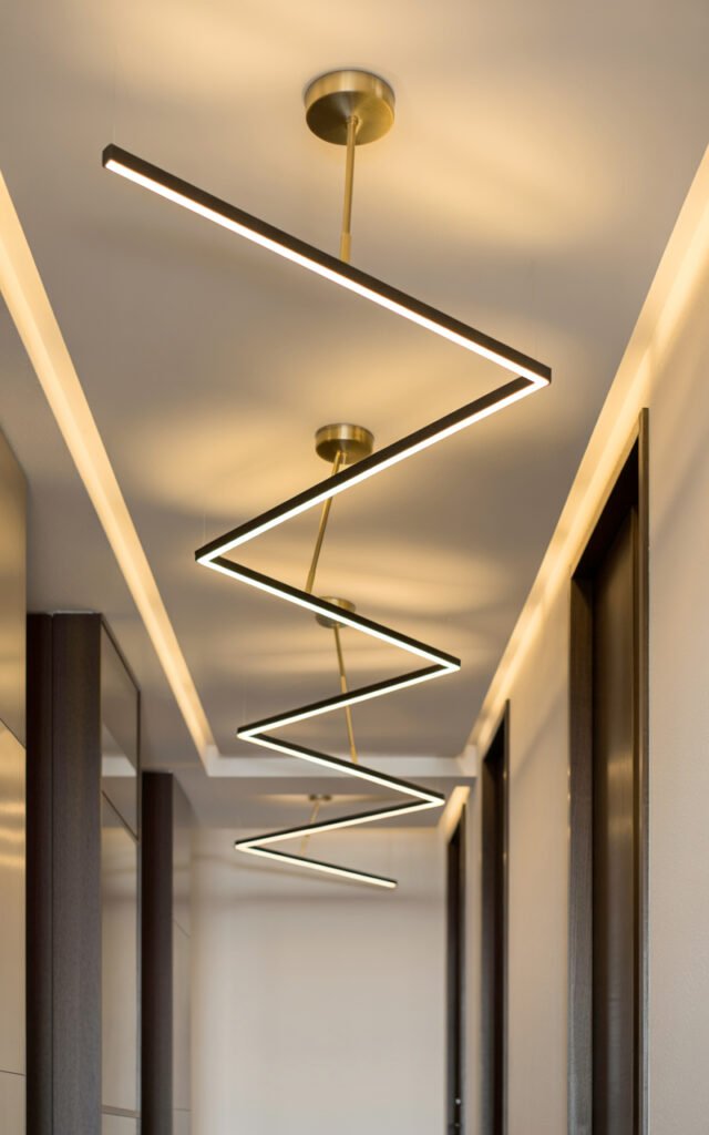 Clean geometric black and brass light fixtures in modern minimalist hallway design