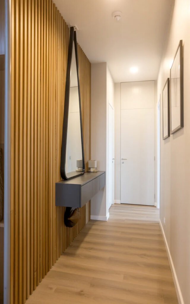 Full view of contemporary narrow corridor featuring floor-to-ceiling wood slats, floating storage and minimal design