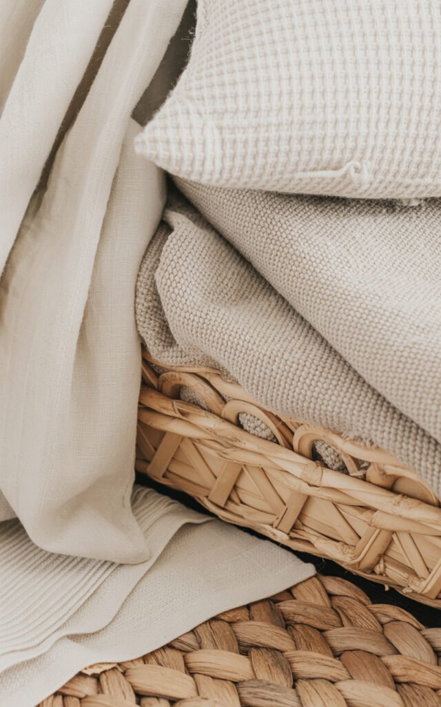 Close-up of various natural fabric textures including linen, cotton and knit in neutral tones