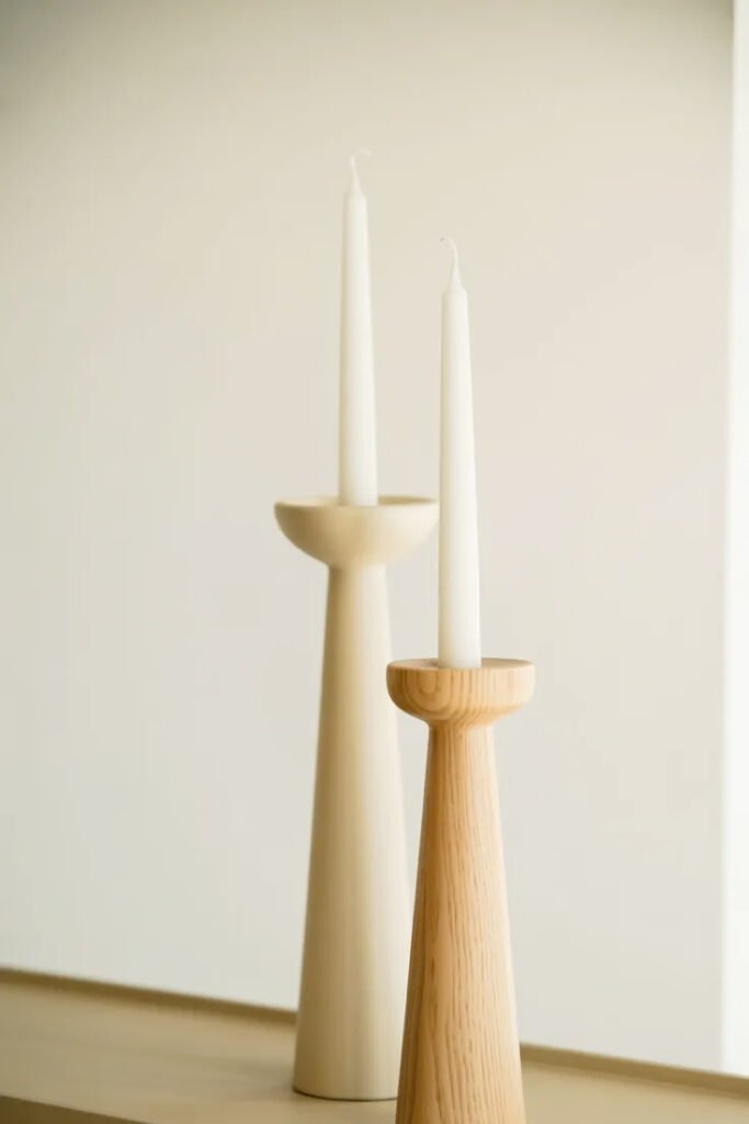 Pair of simple candlesticks in neutral tones providing vertical interest on console table