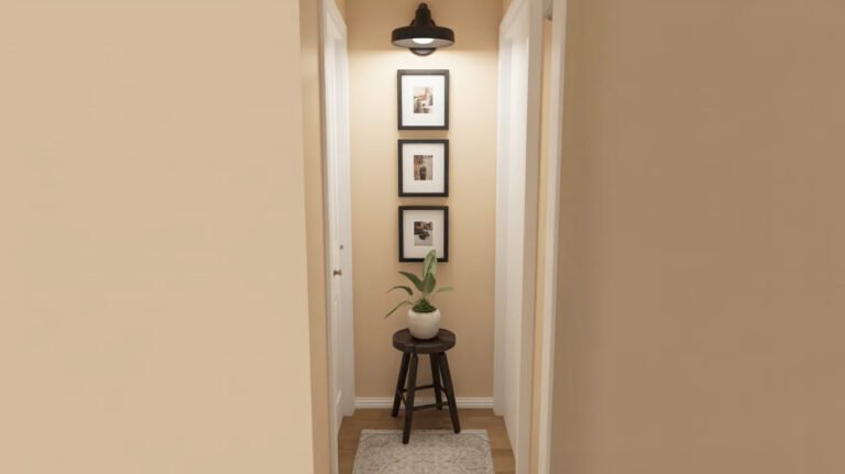 Tiny entrance featuring stacked black-framed photos, small plant stand and simple styling