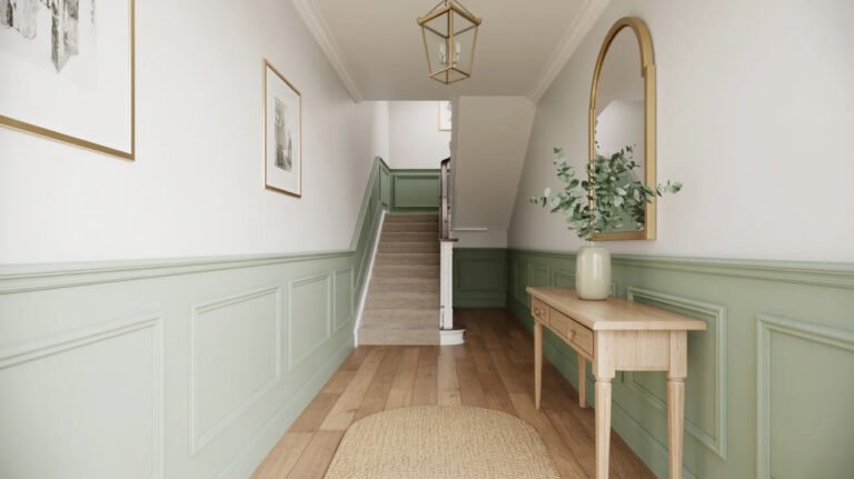 Elegant entrance hall featuring sage painted wainscoting, console table, arched mirror and classic details